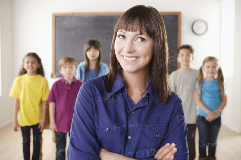 Teacher with group of pupils in front of blackboard. 
Photo : Rob Lewine