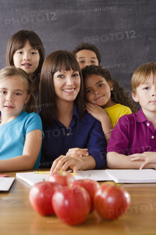 Teacher with group of pupils and apples on desk. 
Photo: Rob Lewine