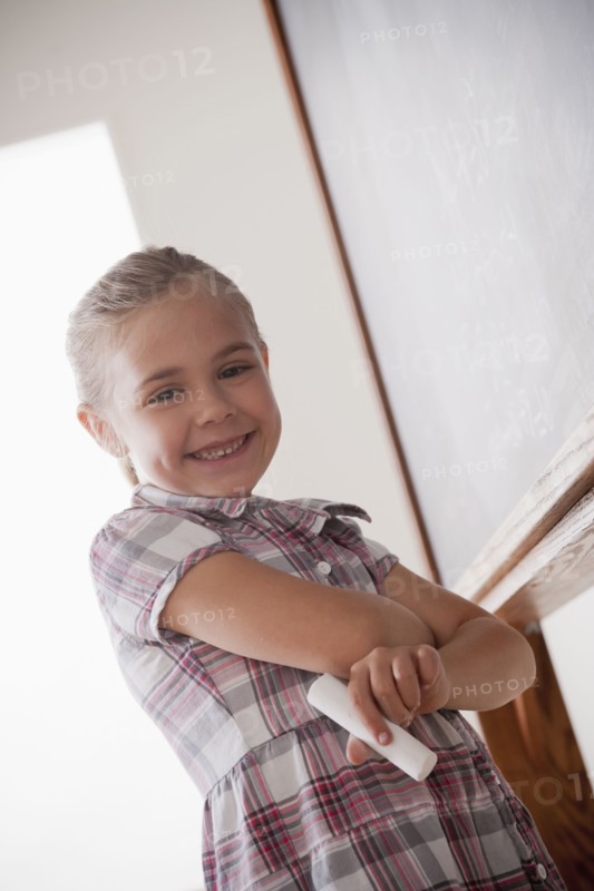Portrait of schoolgirl holding chalk. 
Photo: Rob Lewine