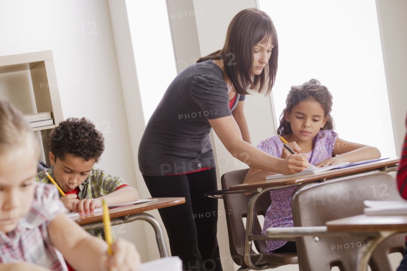 Teacher helping schoolchildren (6-7,8-9). 
Photo : Rob Lewine