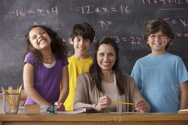 Portrait of pupils (10-11, 12-13) and teacher with blackboard in background. 
Photo : Rob Lewine