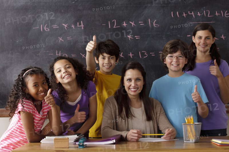 Portrait of pupils (10-11, 12-13) and teacher with blackboard in background. 
Photo : Rob Lewine