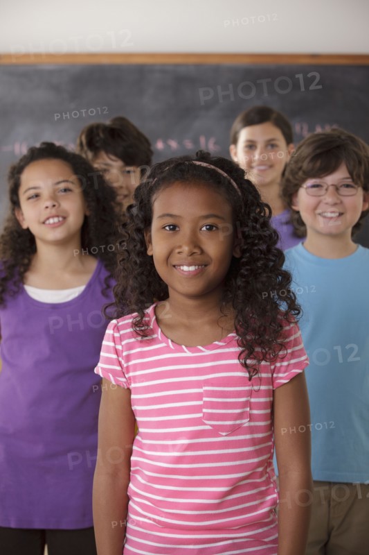 Portrait of pupils (10-11, 12-13) with blackboard in background. 
Photo: Rob Lewine
