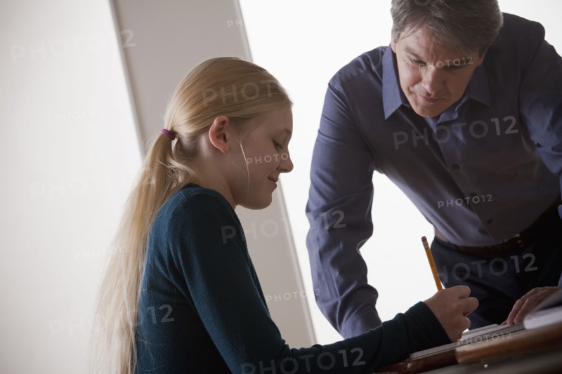 Teenage girl (14-15) with teacher at school. 
Photo : Rob Lewine