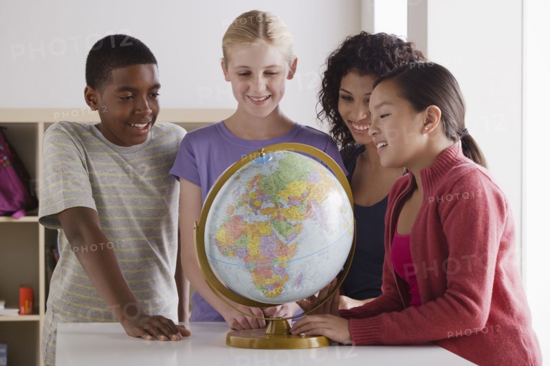 Portrait of teenage students (14-15, 16-17) with globe. 
Photo : Rob Lewine