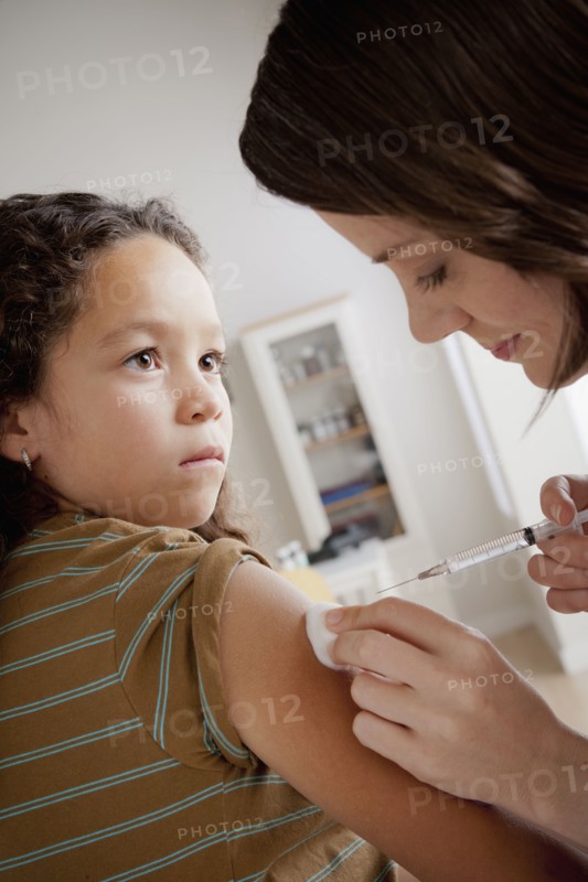 Girl (8-9) having vaccination. 
Photo : Rob Lewine