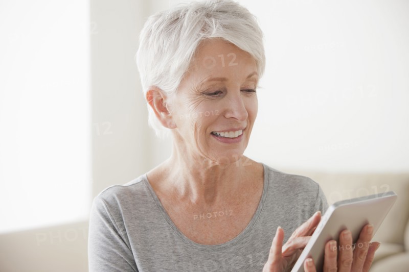 Smiling senior woman using digital tablet. 
Photo : Rob Lewine