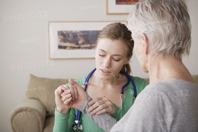 Young female nurse taking pulse of senior woman. 
Photo : Rob Lewine
