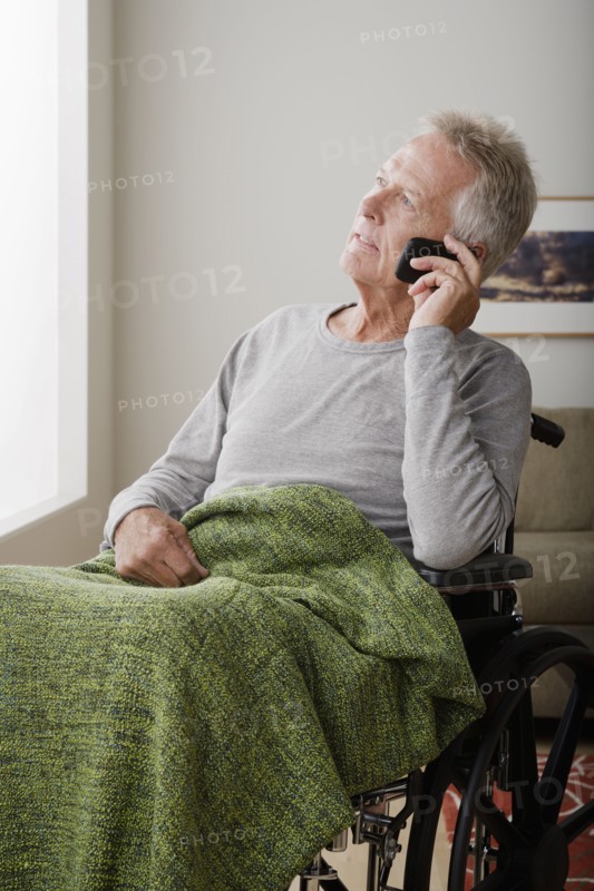 Senior man on wheelchair talking via mobile. 
Photo : Rob Lewine
