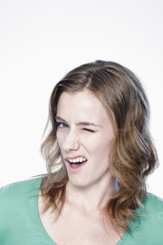 Portrait of young woman blinking eye, studio shot. 
Photo : Rob Lewine