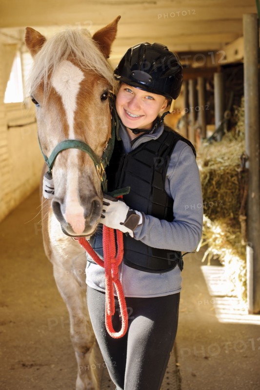 Portrait of teenage girl (16-17) with horse in stable. 
Photo: Elena Elisseeva
