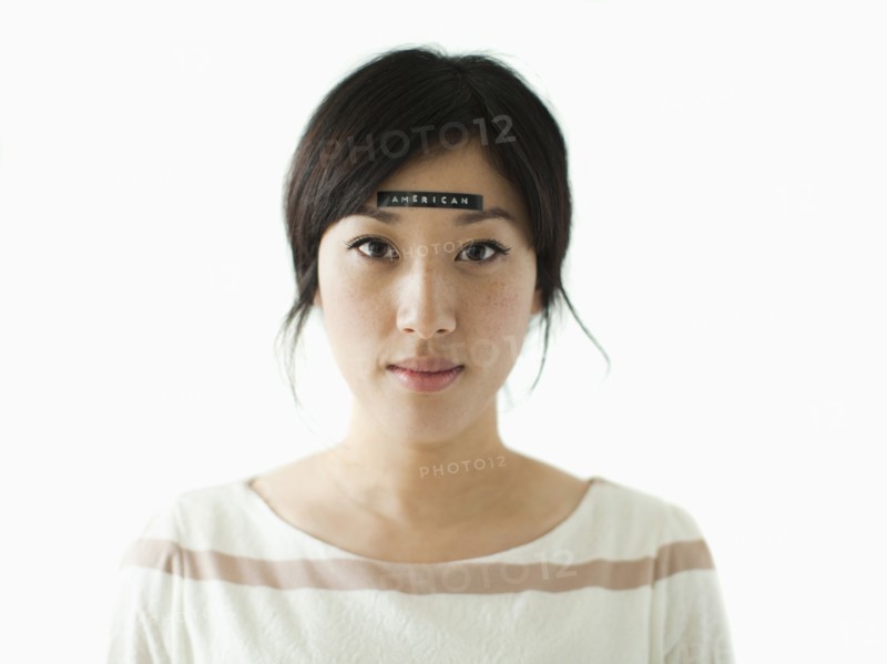 Portrait of young woman with word 'American' on forehead, studio shot. 
Photo: Jessica Peterson