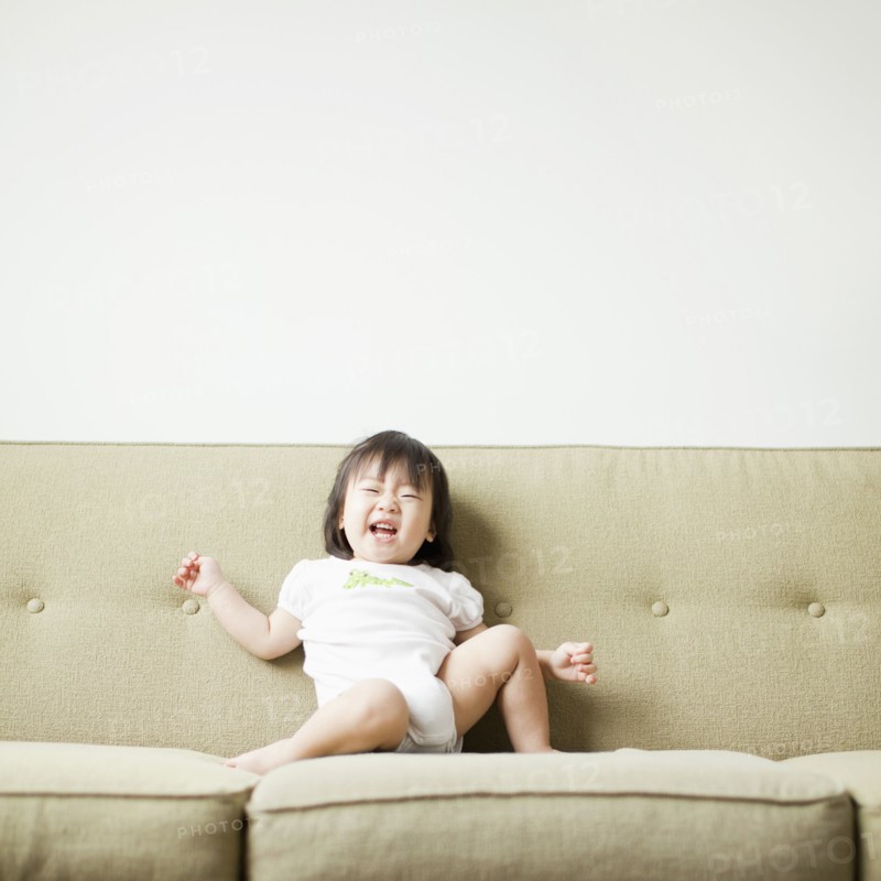 Baby girl (12-17 months) on sofa. 
Photo: Jessica Peterson