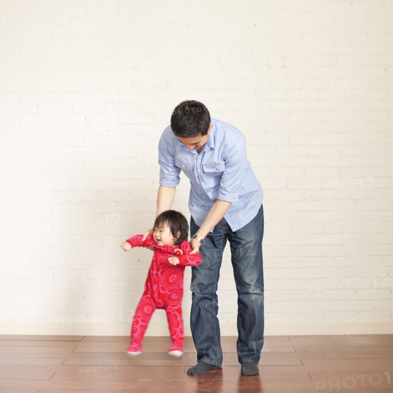 Father helping baby girl (12-17 months) with her first steps. 
Photo: Jessica Peterson
