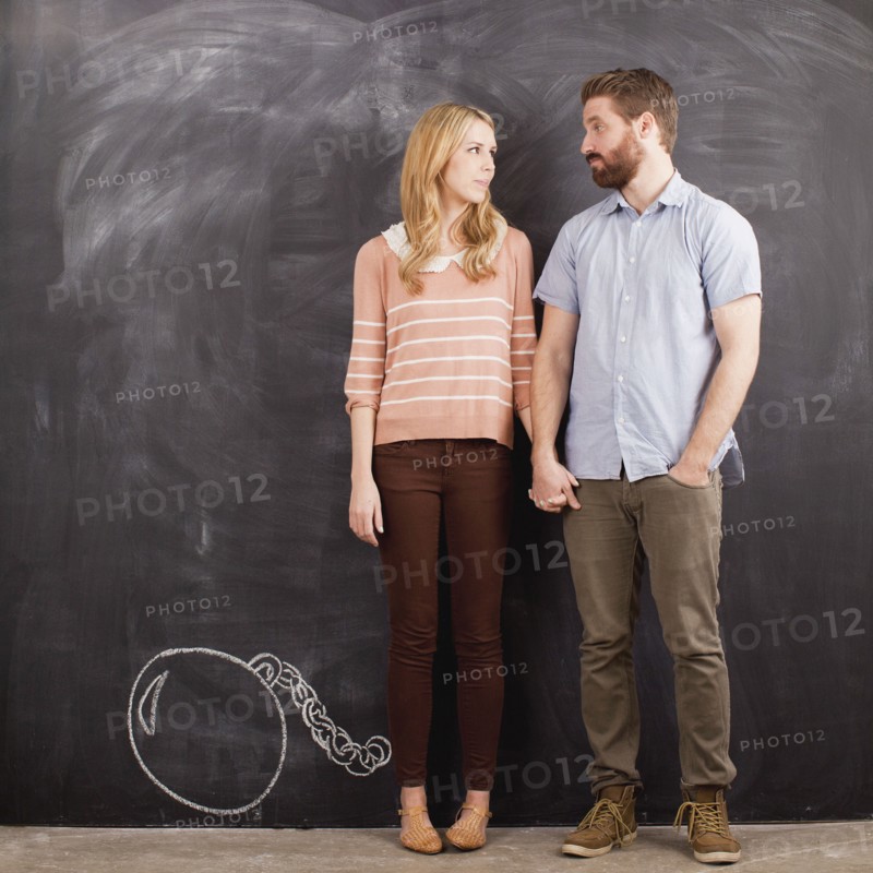 Young couple with blackboard in background, studio shot. 
Photo: Jessica Peterson