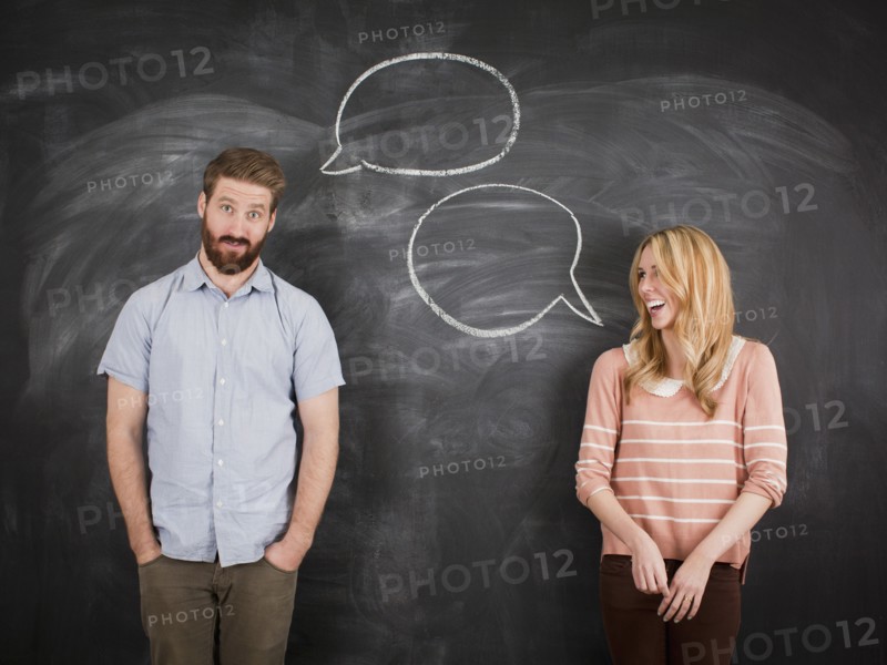 Young couple with speech bubble on blackboard, studio shot. 
Photo: Jessica Peterson