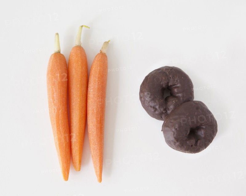 Carrots and chocolate cookies on white background, studio shot. 
Photo: Jessica Peterson