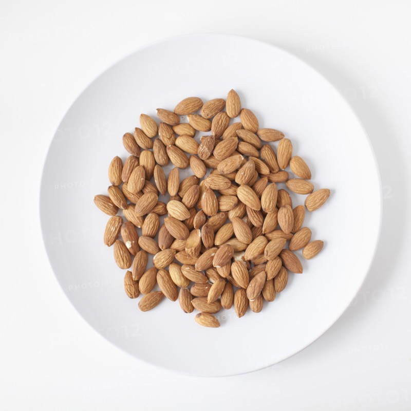 Almonds on plate, studio shot. 
Photo : Jessica Peterson