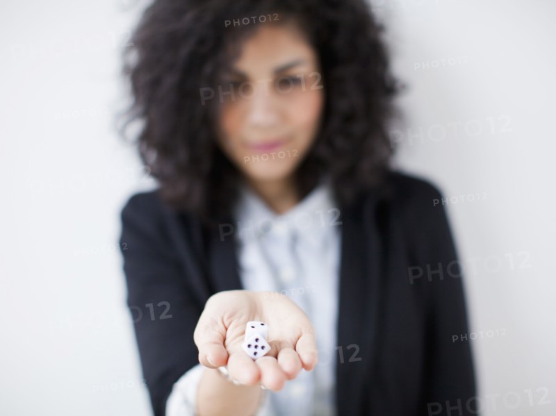 Young woman holding dices. 
Photo: Jessica Peterson