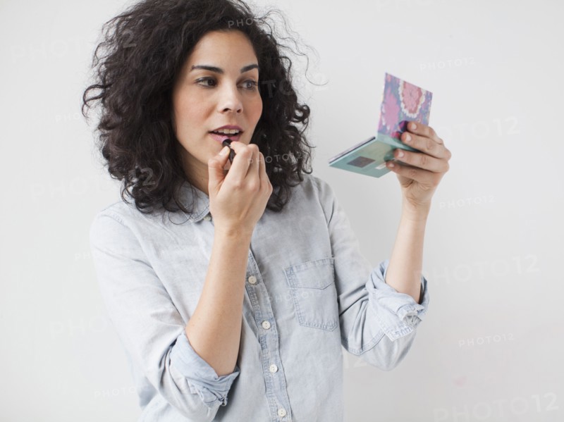 Beautiful young woman applying lipstick. 
Photo: Jessica Peterson