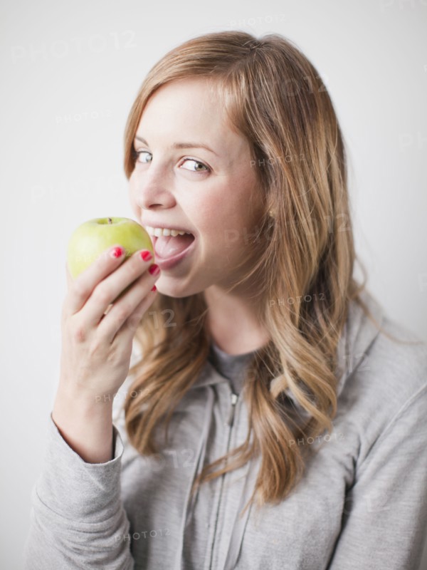 Portrait of attractive young woman holding green apple. 
Photo: Jessica Peterson