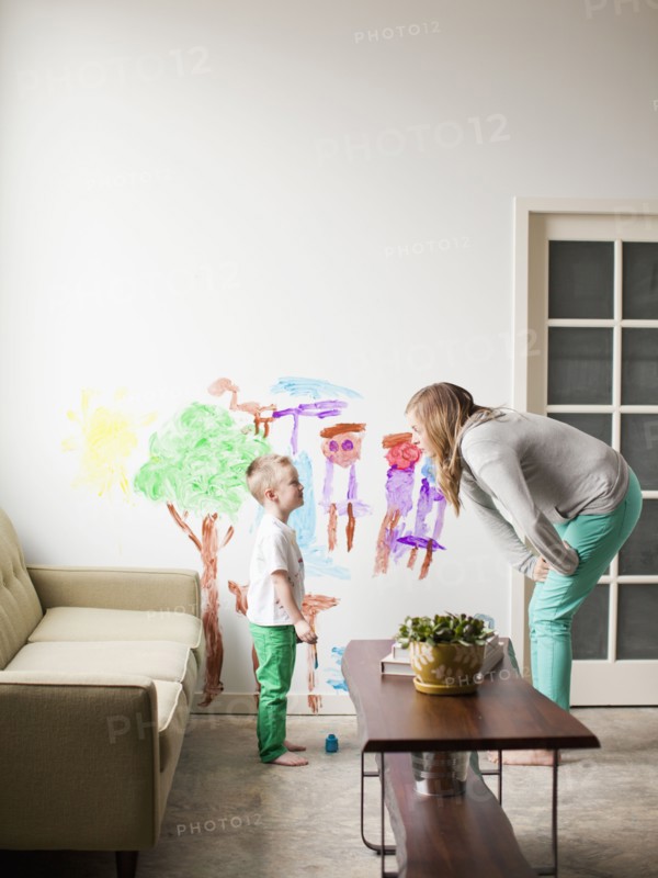 Mother telling toddler boy (2-3) off for painting on walls. 
Photo : Jessica Peterson