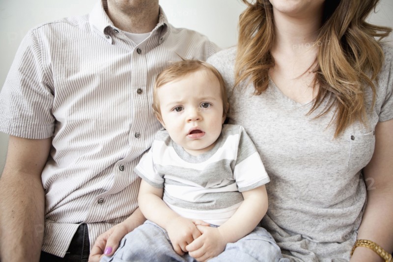 Young couple with baby boy (6-11 months) sitting on sofa. 
Photo: Jessica Peterson
