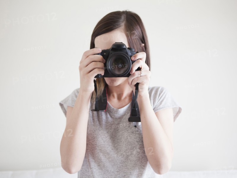 Young woman playing with digital camera. 
Photo : Jessica Peterson