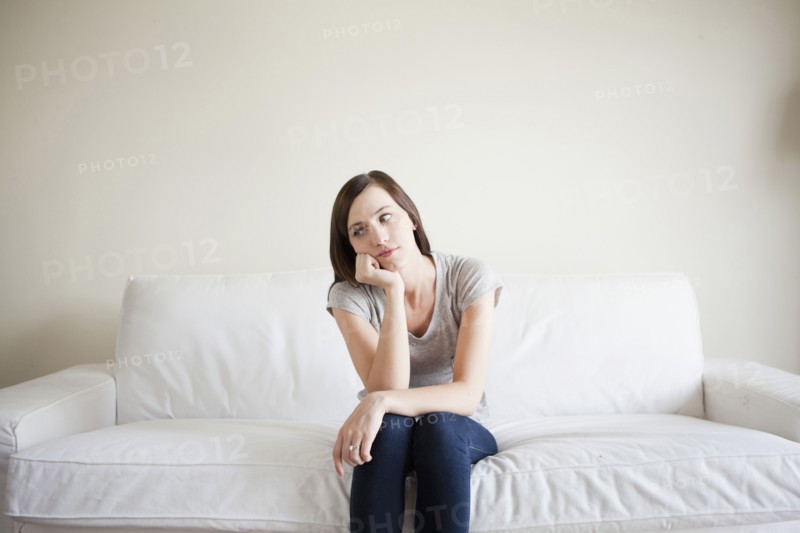 Bored young woman sitting on bed. 
Photo: Jessica Peterson