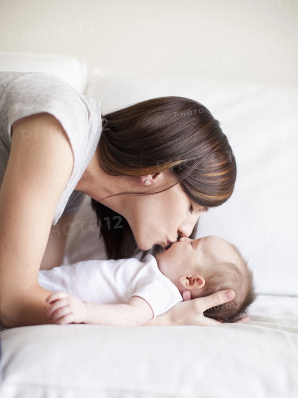 Mother kissing baby girl (2-5 months). 
Photo : Jessica Peterson