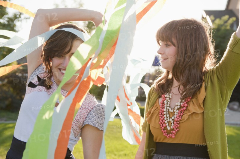 Two happy female friends playing in domestic garden. 
Photo : Jessica Peterson