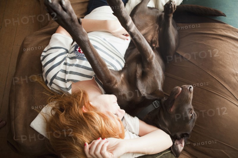 Young woman and her dog sleeping on sofa. 
Photo : Jessica Peterson