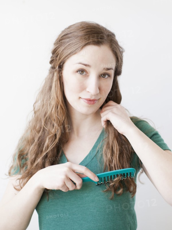 Attractive young woman combing hair. 
Photo : Jessica Peterson