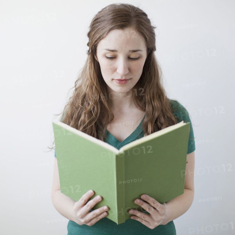 Happy young woman holding green book. 
Photo : Jessica Peterson