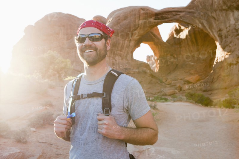 USA, Utah, Moab, Mid adult man posing in front of natural arches. 
Photo : Jessica Peterson