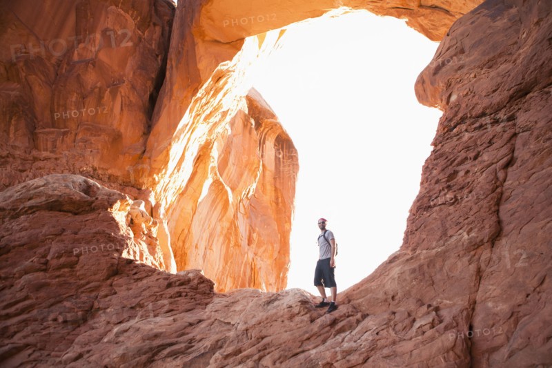 USA, Utah, Moab, Mid adult man posing in front of natural arches. 
Photo : Jessica Peterson