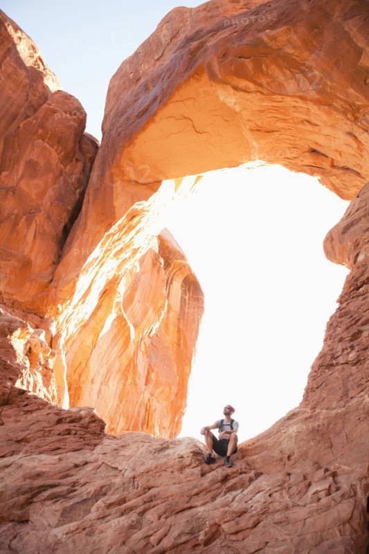 USA, Utah, Moab, Mid adult man posing in front of natural arches. 
Photo : Jessica Peterson