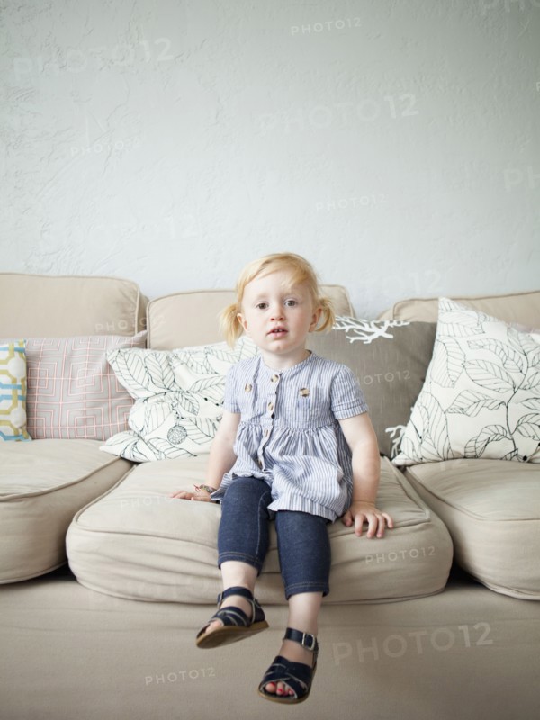 Toddler girl (2-3) sitting on sofa. 
Photo: Jessica Peterson