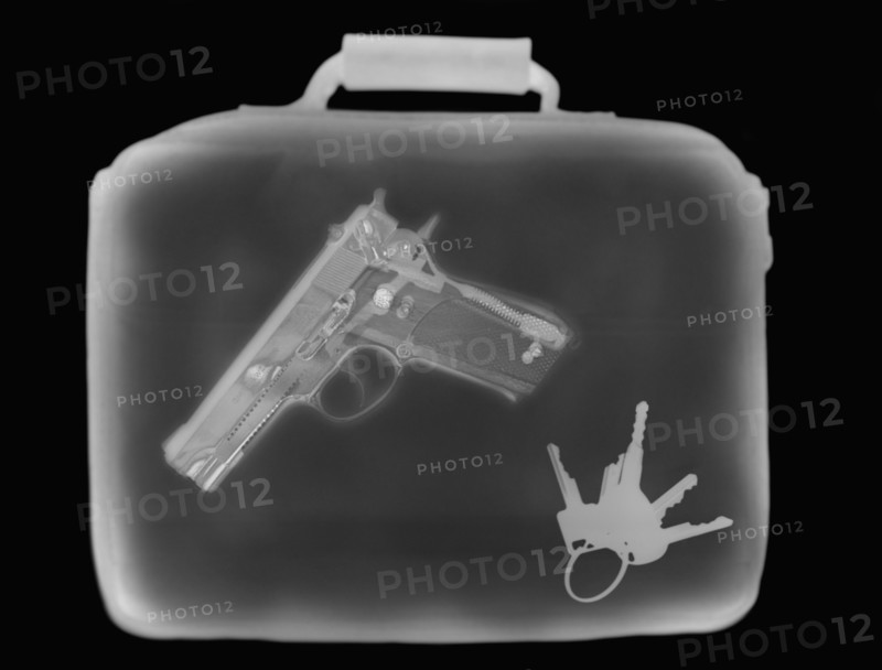 X-ray image showing handbag containing pistol and set of keys. 
Photo : Calysta Images