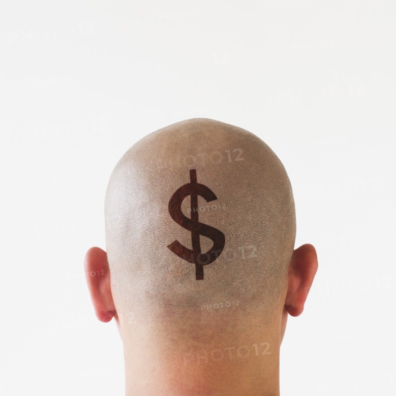 Back view of man with dollar sign on shaved head.