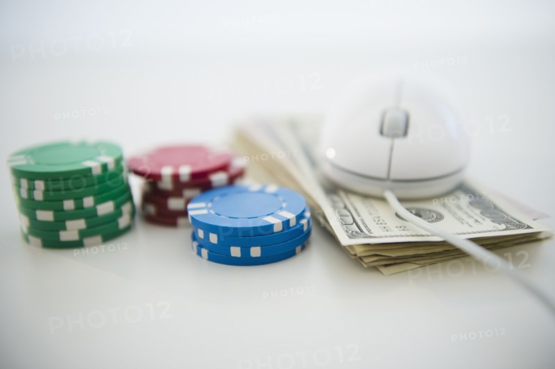 Roulette tokens, dollar bills and computer mouse. Photo: Jamie Grill