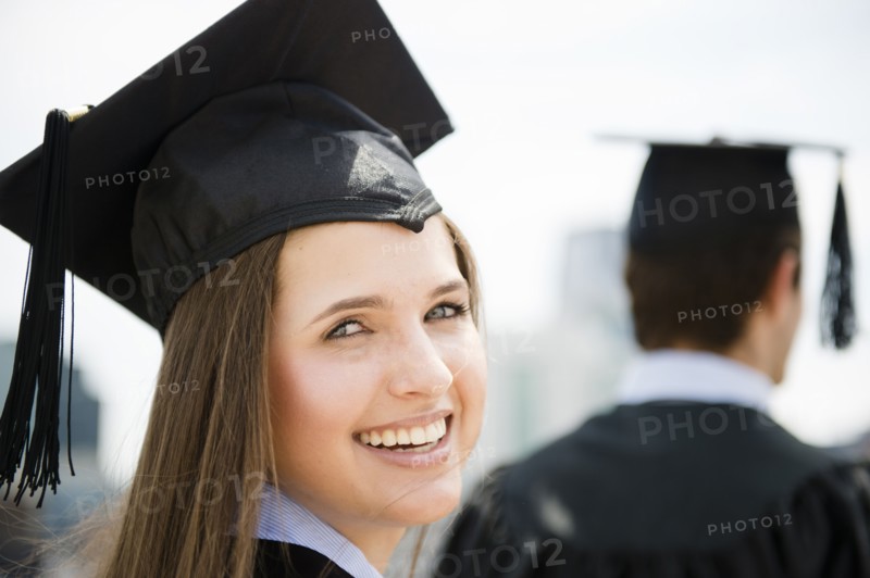 Young man and woman wearing graduation gowns. Photo: Jamie Grill