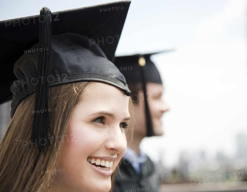Profiles of young man and woman wearing graduation gowns. Photo: Jamie Grill