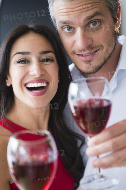 Couple toasting with red wine. Photo : Jamie Grill