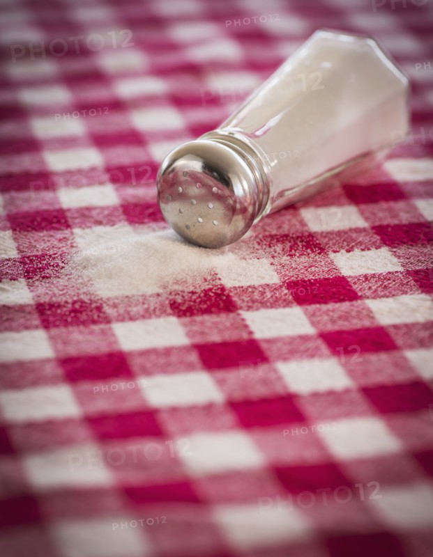 Salt shaker on checked tablecloth. Photo : Daniel Grill
