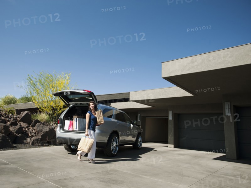 Woman with groceries leaving car.