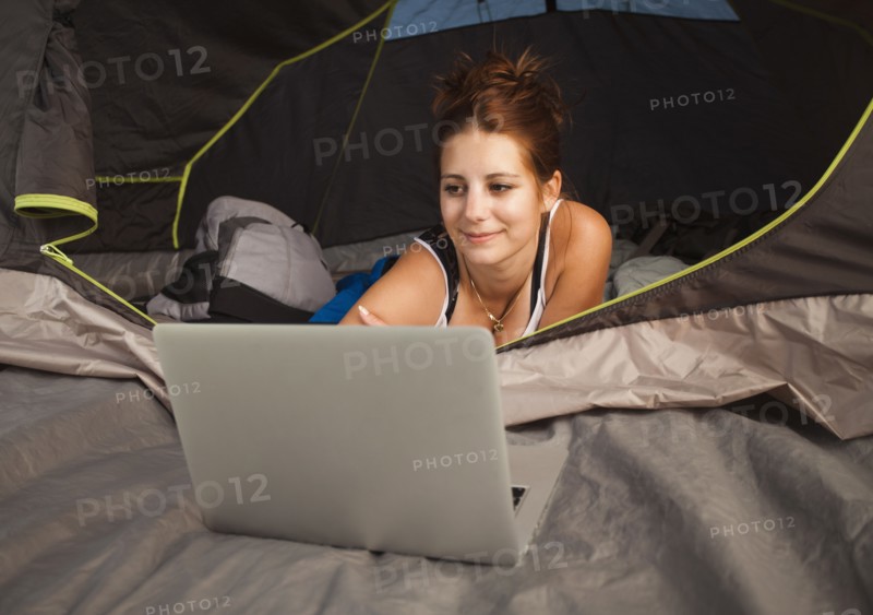 Hiker in tent using laptop. Photo : Mike Kemp