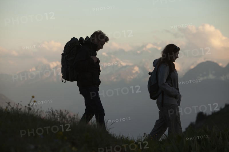 Switzerland, Leysin, Hikers marching through Alpine landscape. Photo: Mike Kemp