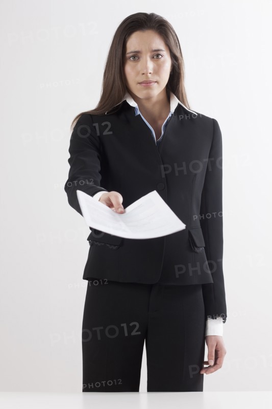 Studio shot of businesswoman holding document. Photo: Jan Scherders