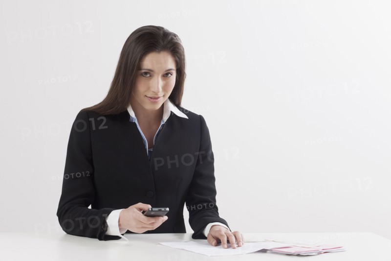 Young woman paying bill with her mobile phone. Photo : Jan Scherders